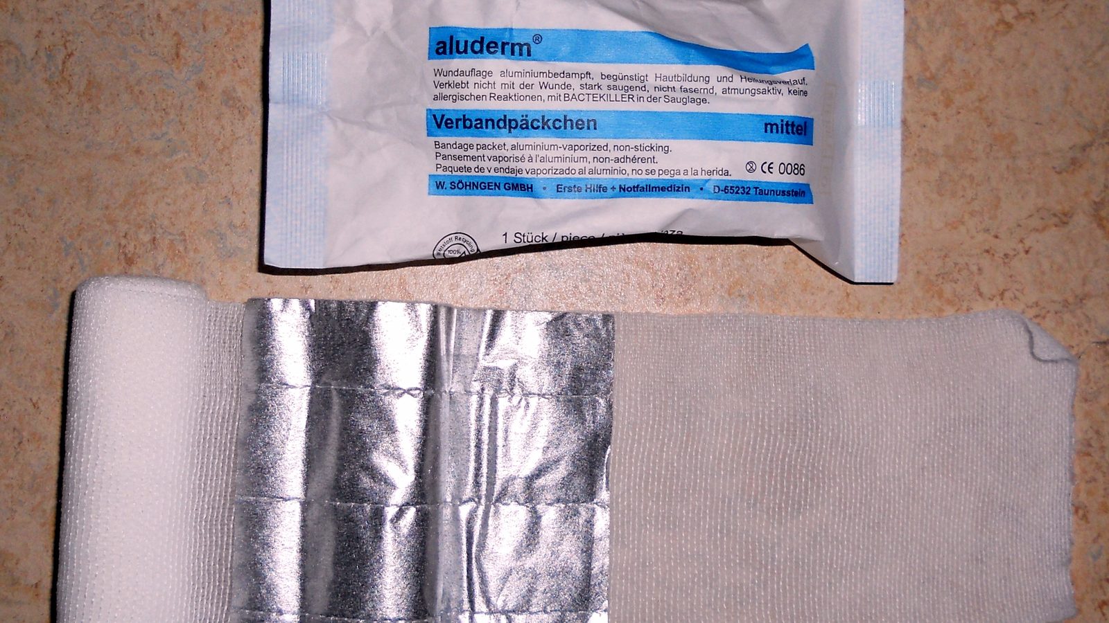 A closed individual first aid kit pouch or a packaged compression bandage laid on a flat surface, with no people visible.